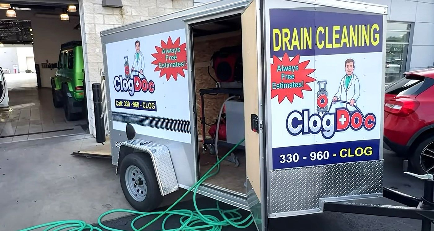Clog Doc hydro-jetting trailer with the door open and green hose on the ground